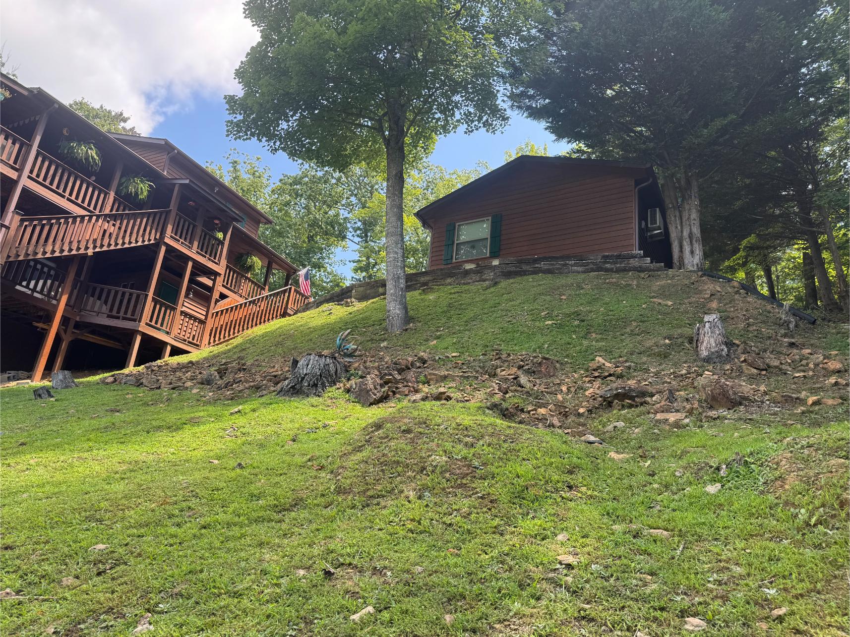 Cabins on a hillside surrounded by greenery and trees.